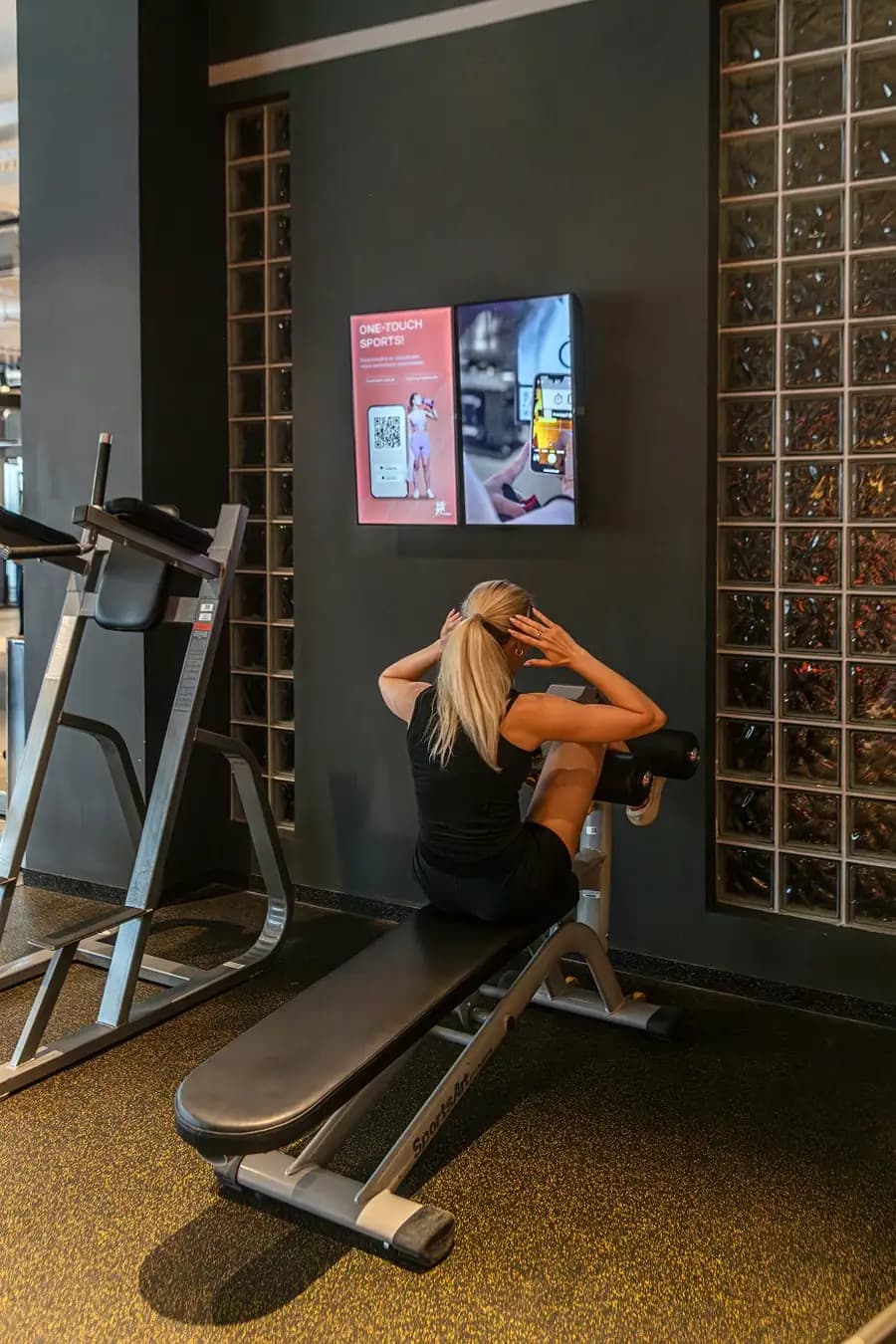 Member training beside a double screen running a promo and a class video