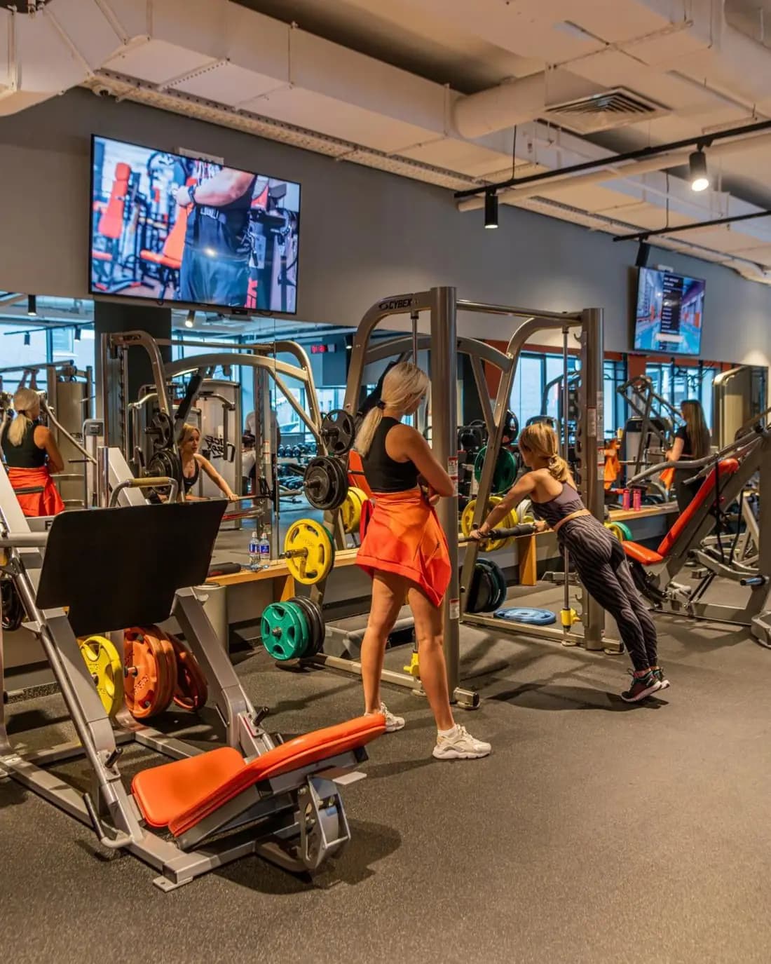 Gym floor with a wall-mounted screen showing club content